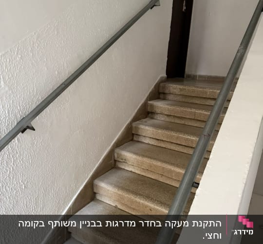 מדרגות עם מעקה מתכת ליד קיר לבן